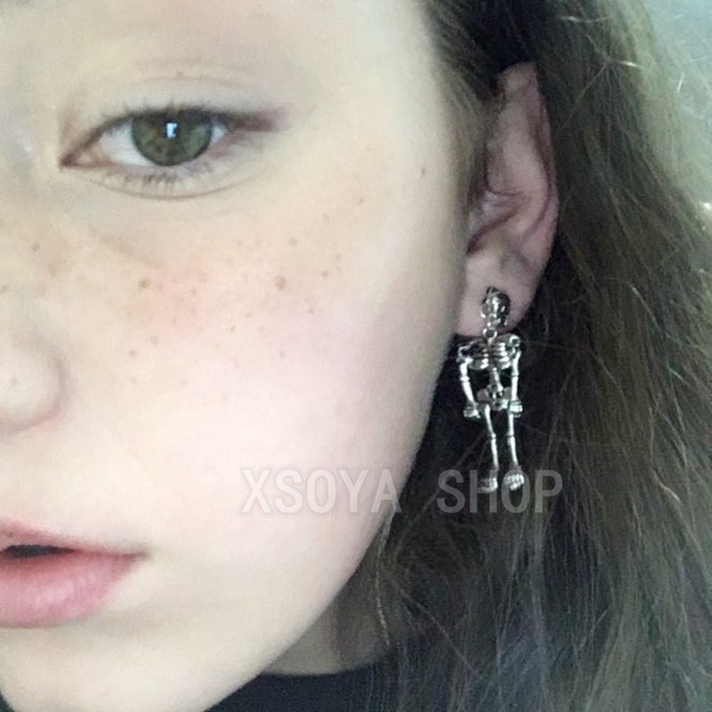 A pair of playful small stud earrings with movable hands and feet of punk INS skull